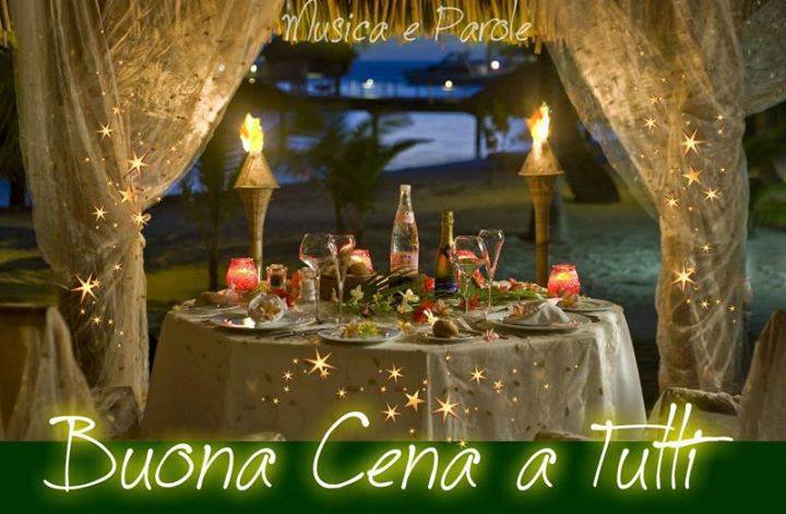 Una cena romantica allaperto di notte, con la scritta Buona Cena a tutti