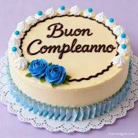 Torta di compleanno decorata con panna, scritta in cioccolato e rose blu