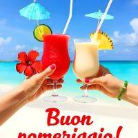Due cocktail tropicali brindano in spiaggia, con ombrellini e frutta; sullo sfondo mare turchese e cielo azzurro