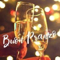 Due calici brindano, sfondo luminoso, scritto 'Buon Pranzo'