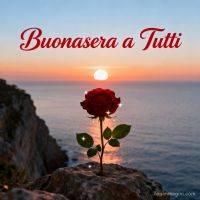 Rosa rossa su uno scoglio al tramonto sul mare, con scritta di saluto in alto
