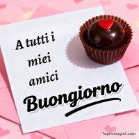Biglietto “A tutti i miei amici buongiorno” con cioccolatino al cuore rosso su sfondo rosa