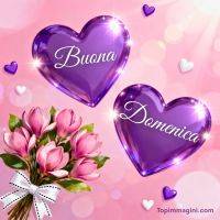 Cuori viola scintillanti e bouquet di fiori rosa su sfondo rosa, con augurio di buona domenica