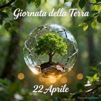 Albero in una sfera di vetro incrinata tra foglie verdi, con data del 22 aprile