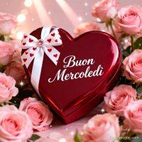 Scatola a forma di cuore rosso con fiocco e scritta “Buon mercoledì”, circondata da rose rosa