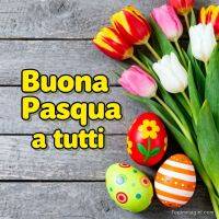 Tulipani colorati e uova di Pasqua decorate su legno, con scritta “Buona Pasqua a tutti”