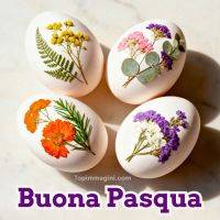 Quattro uova bianche decorate con fiori secchi e foglie; in basso la scritta “Buona Pasqua”