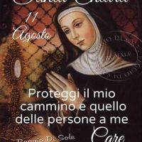 Santa Chiara in preghiera accanto all’ostensorio, con invocazione e data 11 agosto su sfondo decorato