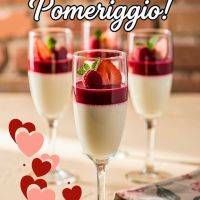 Tre bicchieri di dessert panna e frutti rossi con fragole, lamponi e scritta “Buon Venerdì Pomeriggio!”